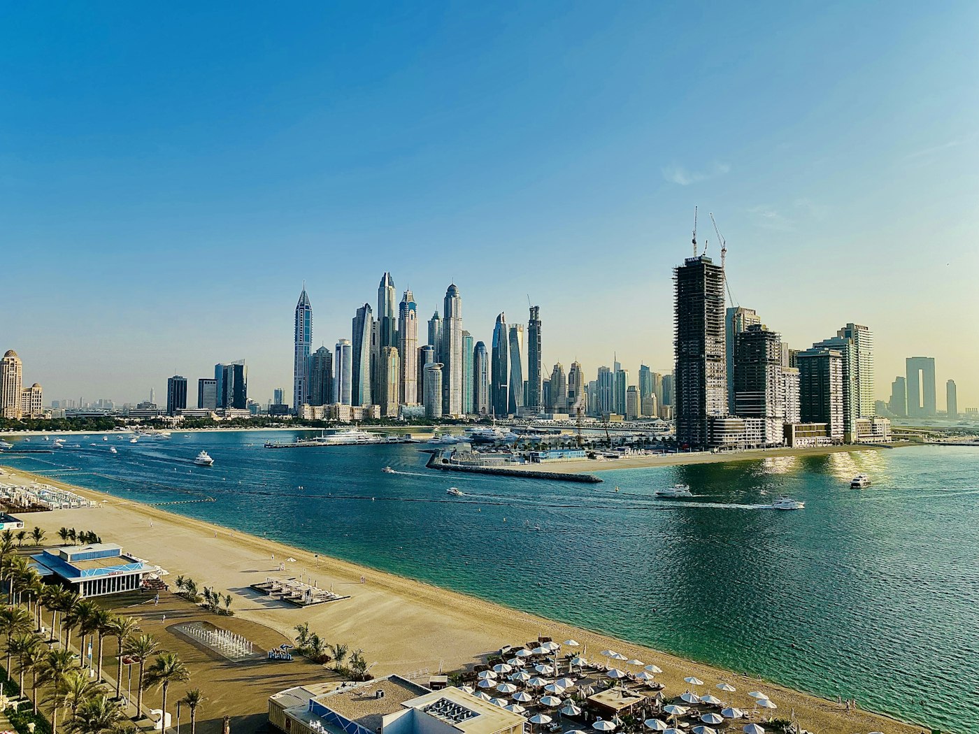 Palm West Beach и его пляжные клубы, на другом берегу силуэт Dubai Marina