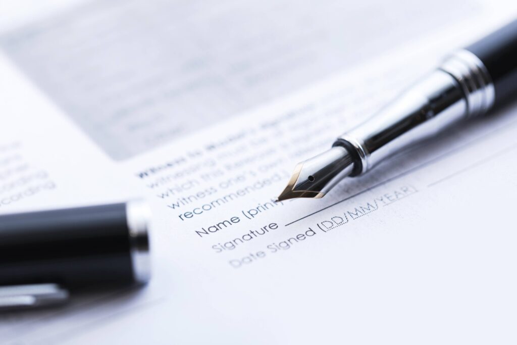Fountain pen resting on a signed agreement
