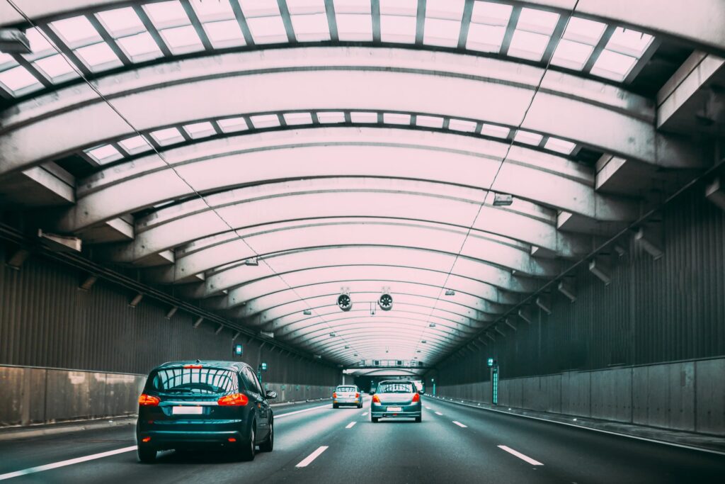 Cars driving through a modern lit road tunnel