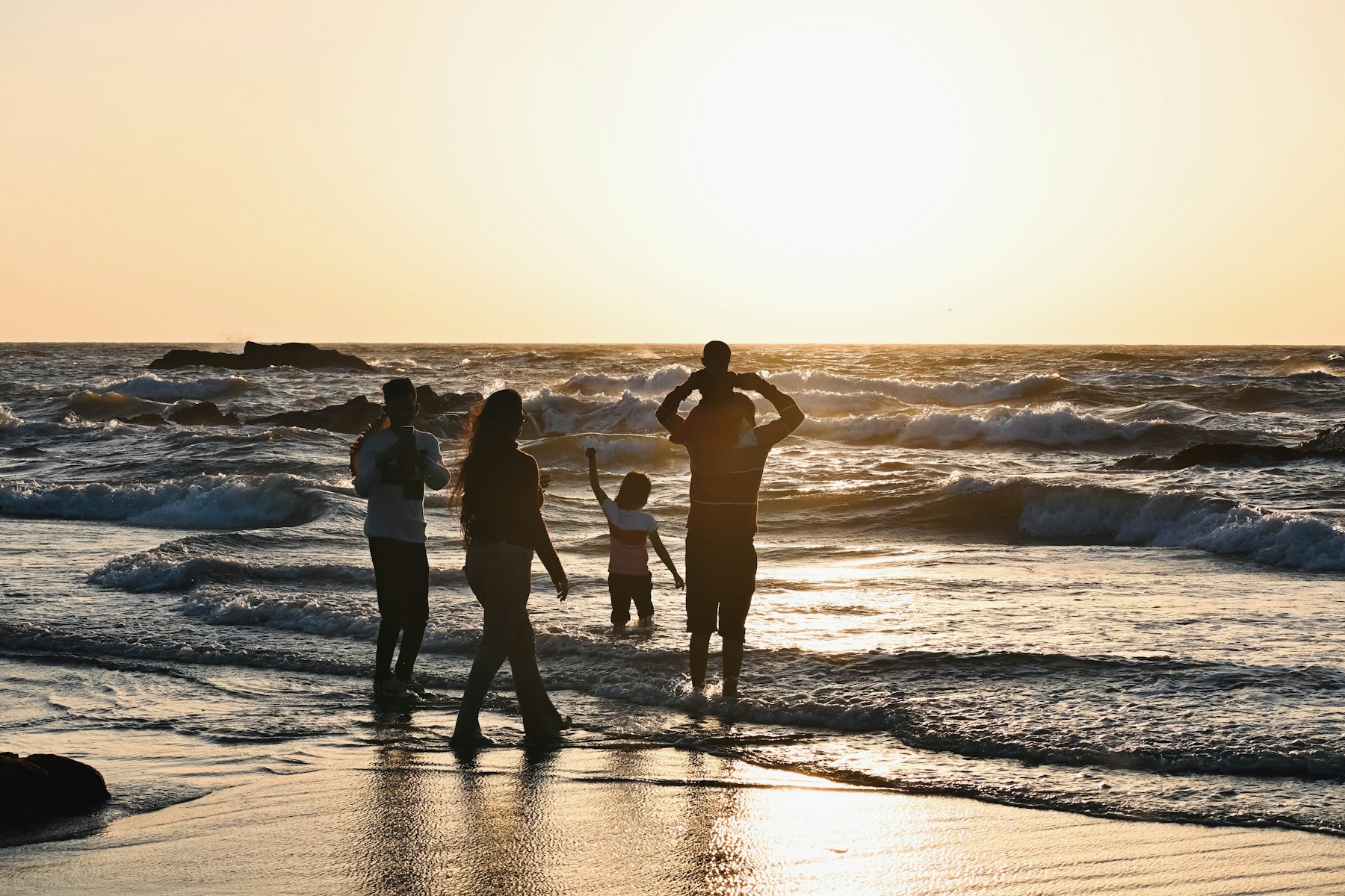 Family walking on the beach at sunset