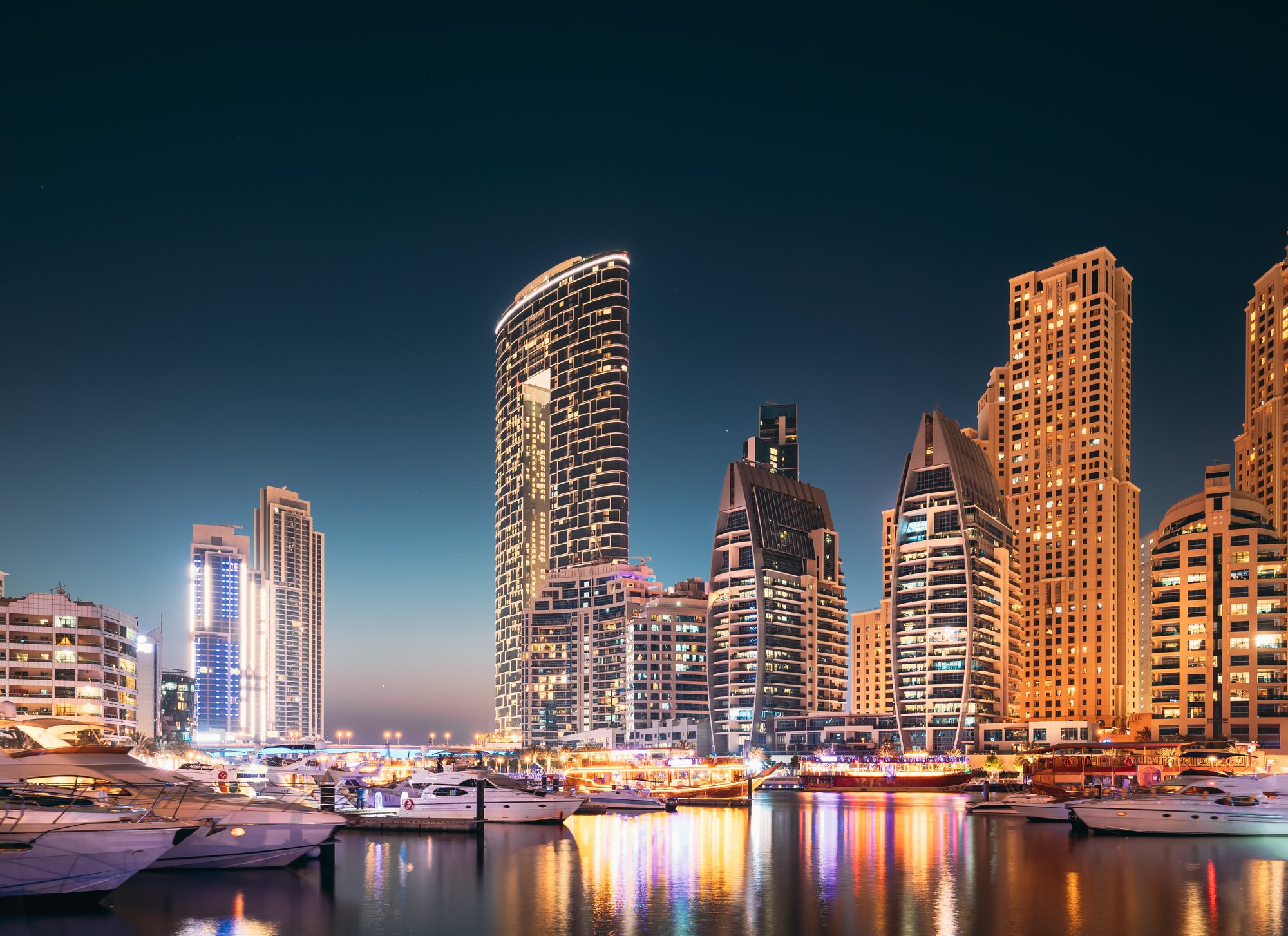 Die Hochhäuser der Dubai Marina und vor Anker liegende Yachten in der blauen Stunde