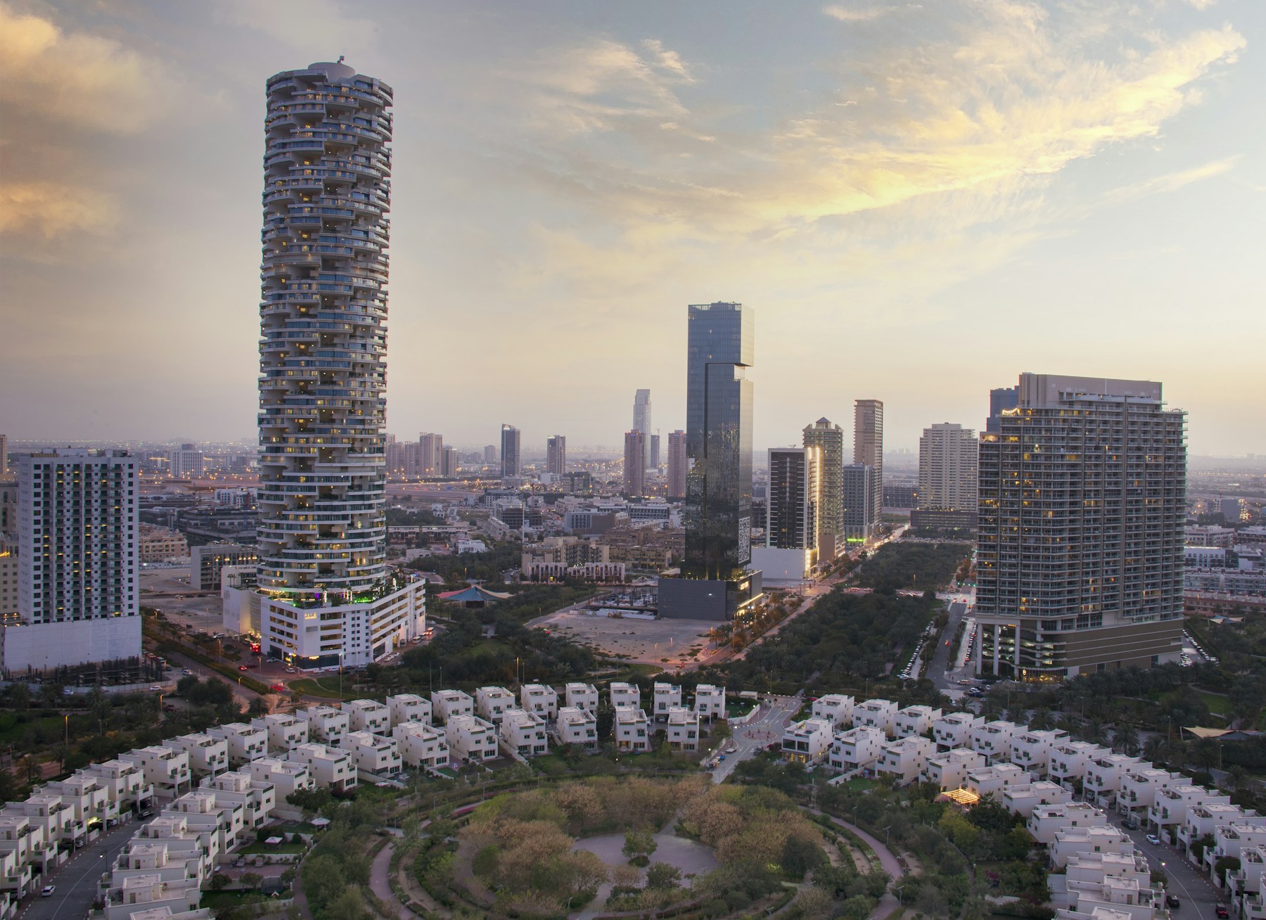 Les villas de Jumeirah Village Circle, avec des tours résidentielles en arrière-plan, au coucher du soleil